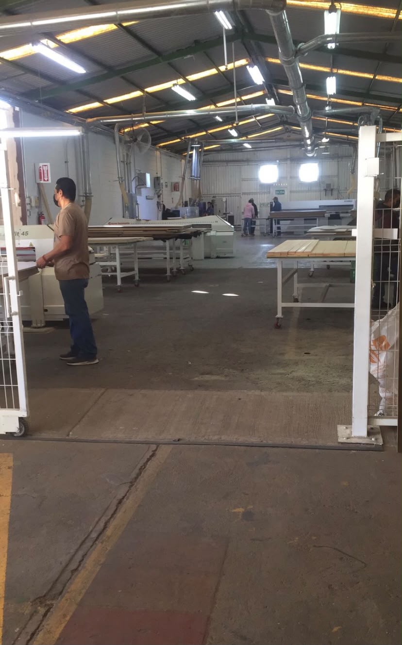 Nave de producción con mesas de trabajo y maquinaria